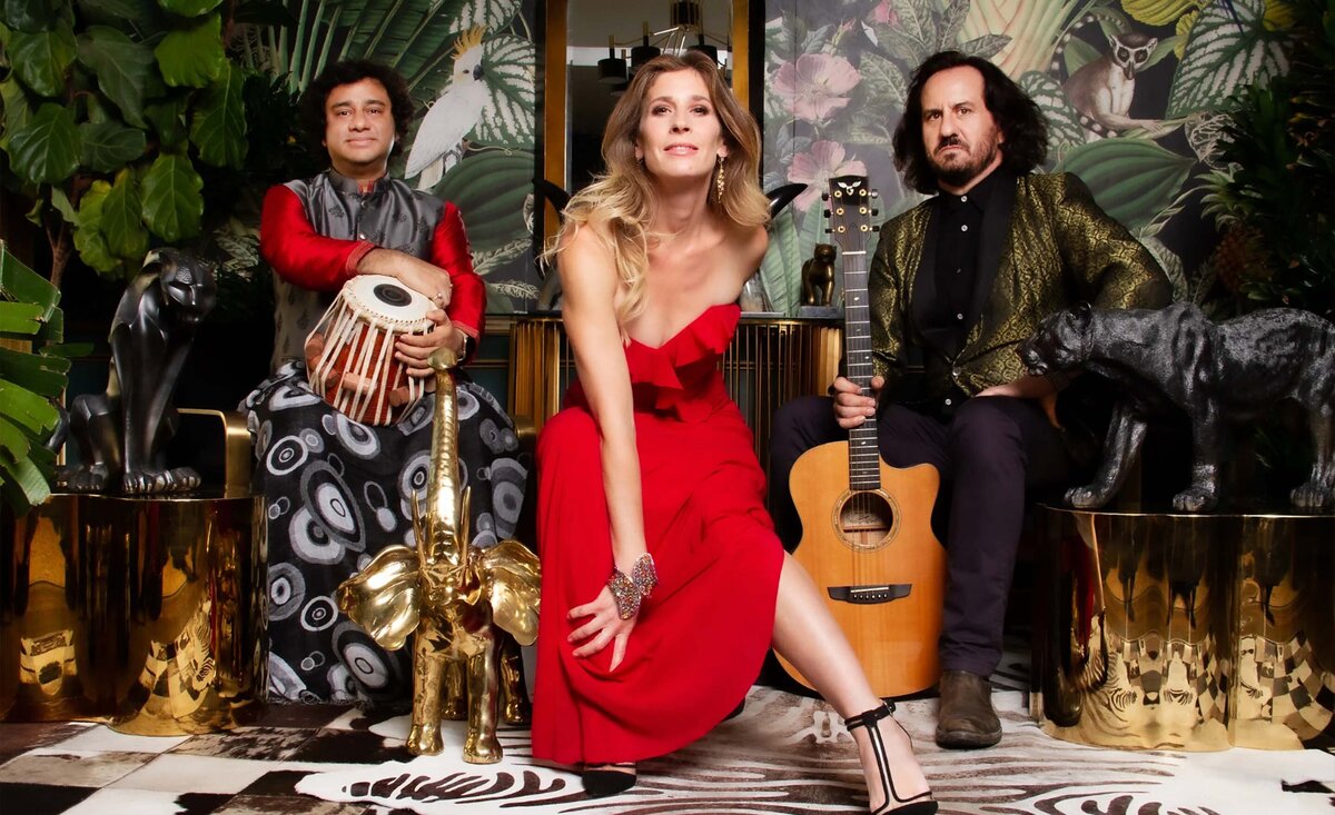 Musical trio portrait Renaissance Heart sitting with instruments  amidst animal statues against jungle background