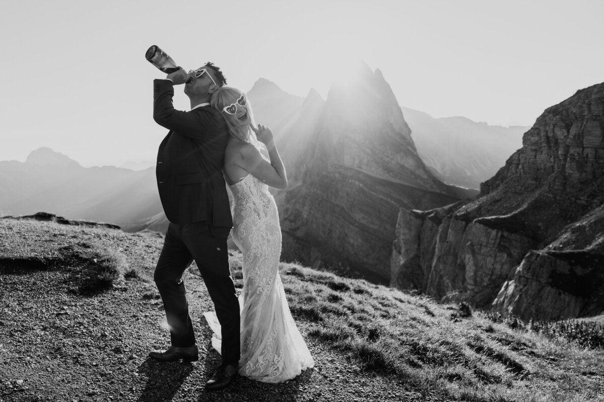 Bride and groom celebrating with champagne bottle Seceda