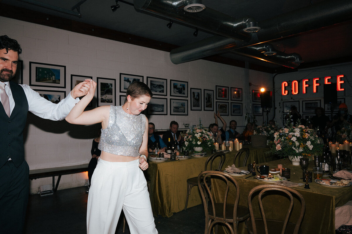 A woman steps onto the dance floor holding her partner'c faceless hand as they celebrate their vow renewal in Boise. 