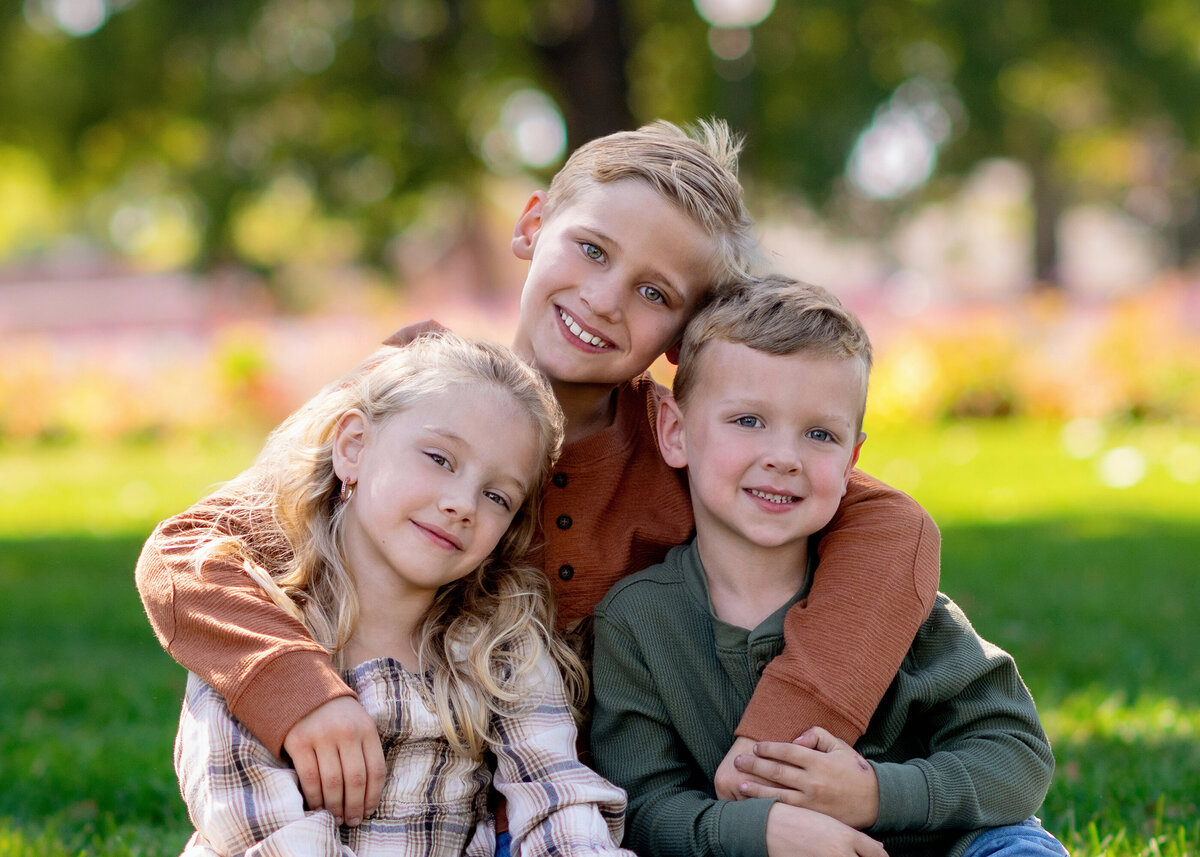 Closeup of 3 siblings smiling for their Pella Senior Photographer