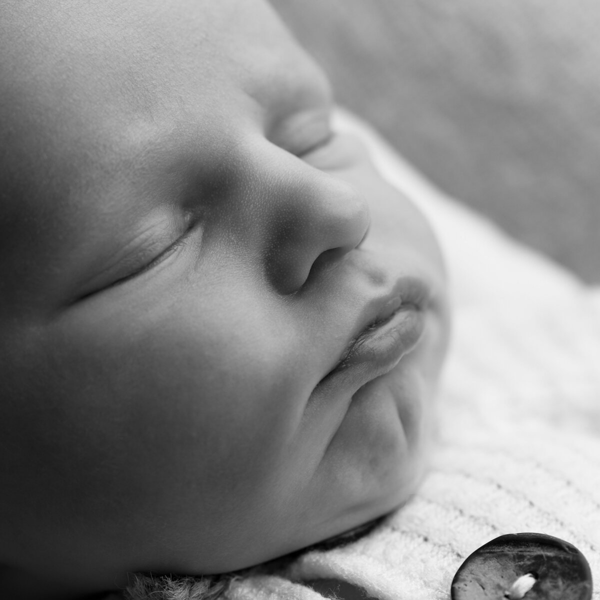 A tranquil black and white newborn macro portrait, focused on baby’s sleeping face—pure, serene, and timeless.