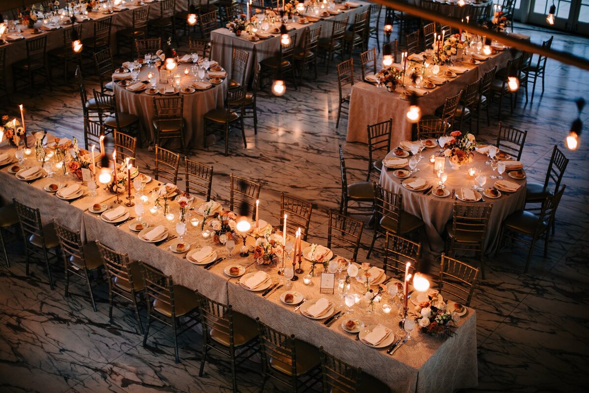 An overhead view of a wedding reception with twinkling lights and a warmly lit atmosphere