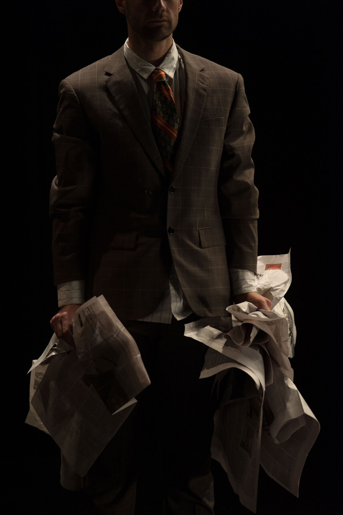 Man in suit hold crumpled newspapers