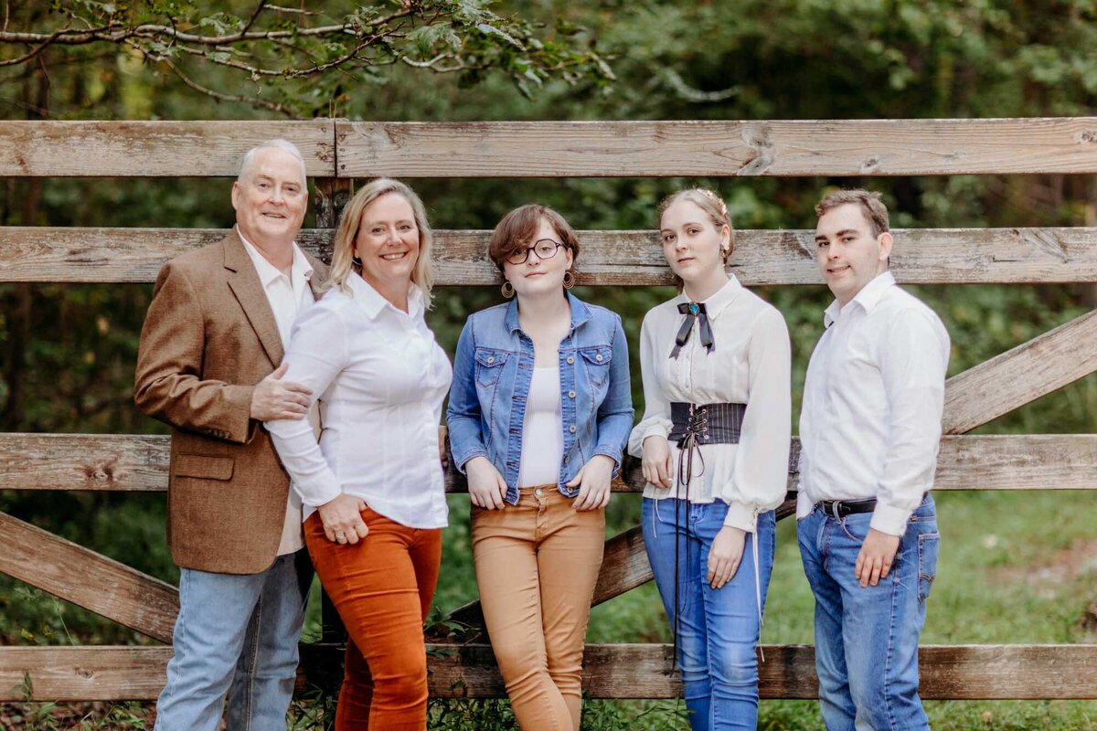 A family portrait against a fence.