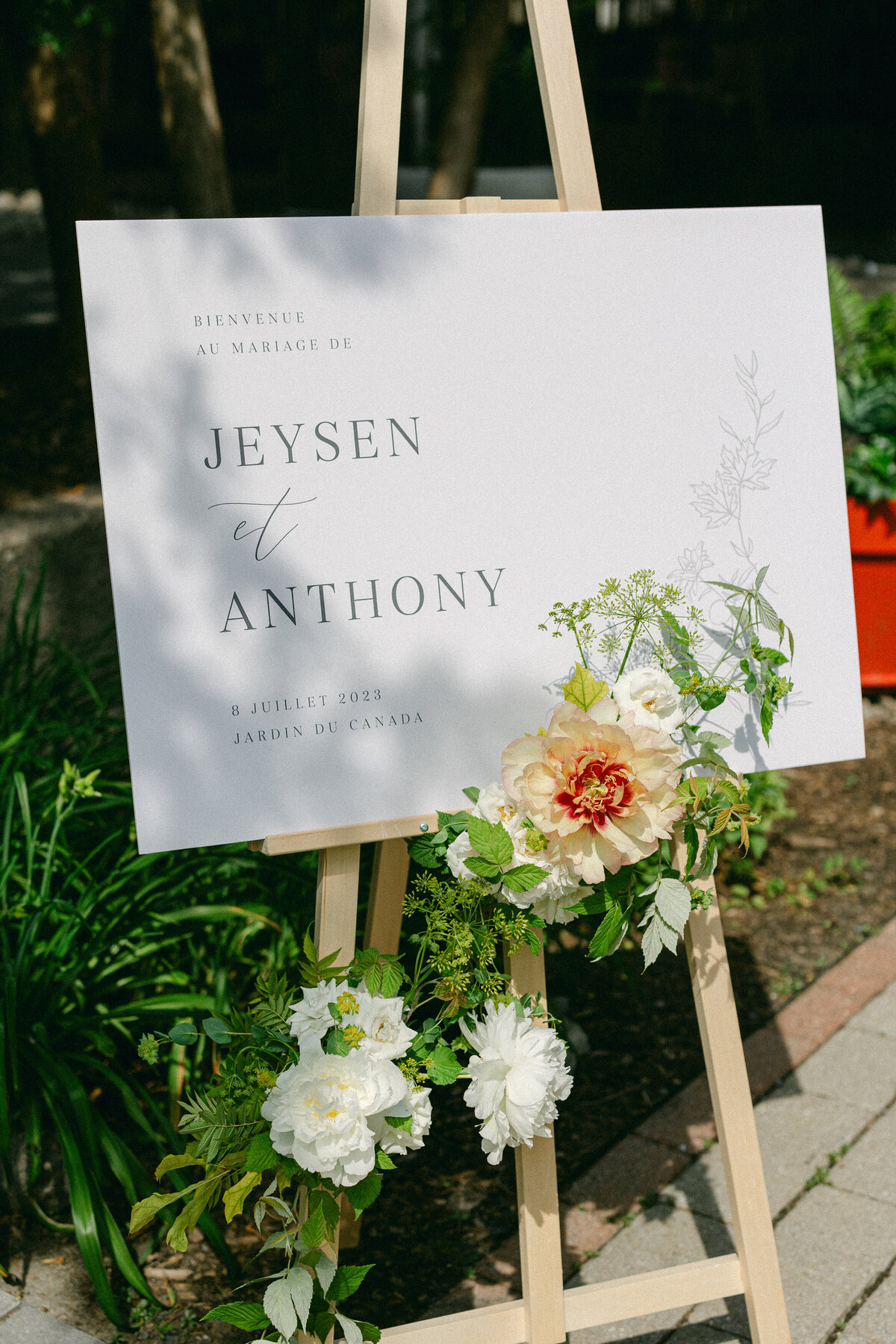Lush spring flowers decorate the welcome sign outside of a La Toundra wedding. 