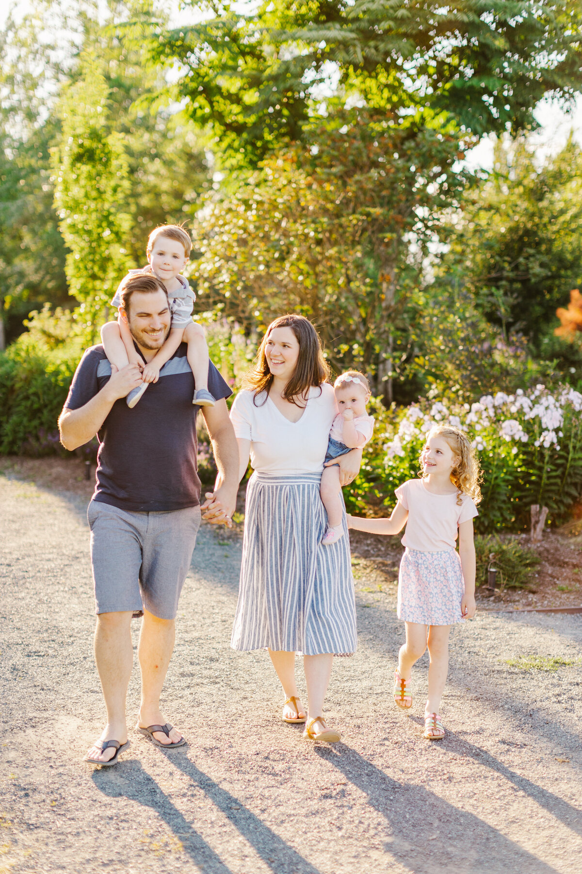 Family of five holding hands and walking while smiling at each other