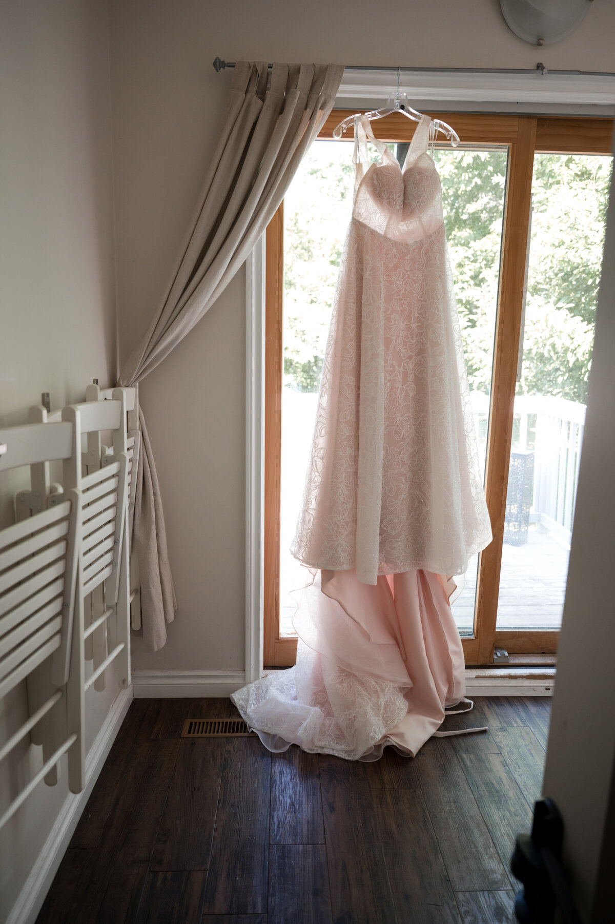wedding dress hanging in a bright window