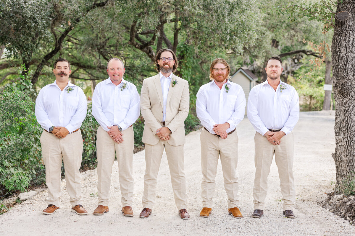 San Antonio groom stands in the middle of his groomsmen as a San Antonio wedding photographer captures the day.