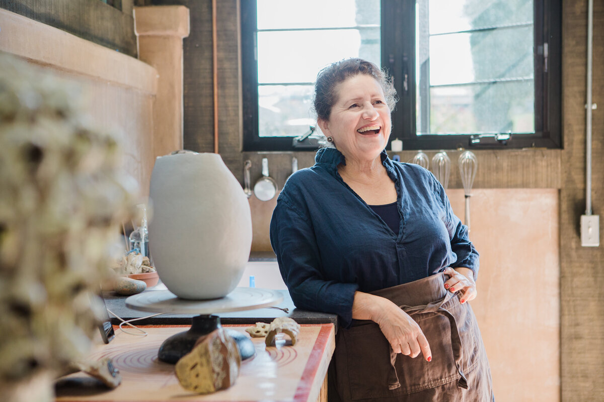 Sylvia Trumbull, ceramicist,  posing in her home studio