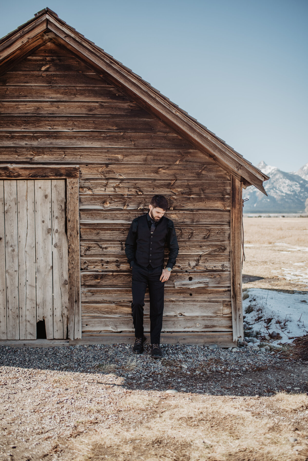 Jackson Hole Photographers capture groom leaning against barn wall