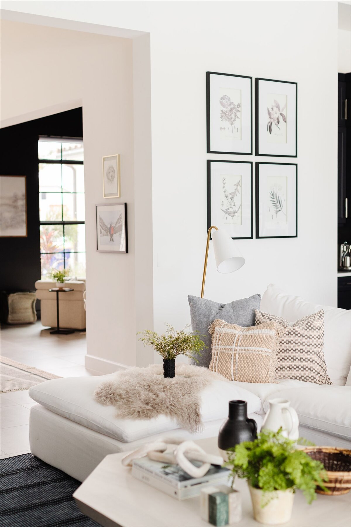 Living room with white couch and white photographs in black frames