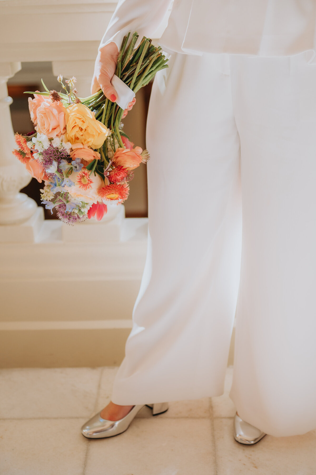 Close up of florals and white pants