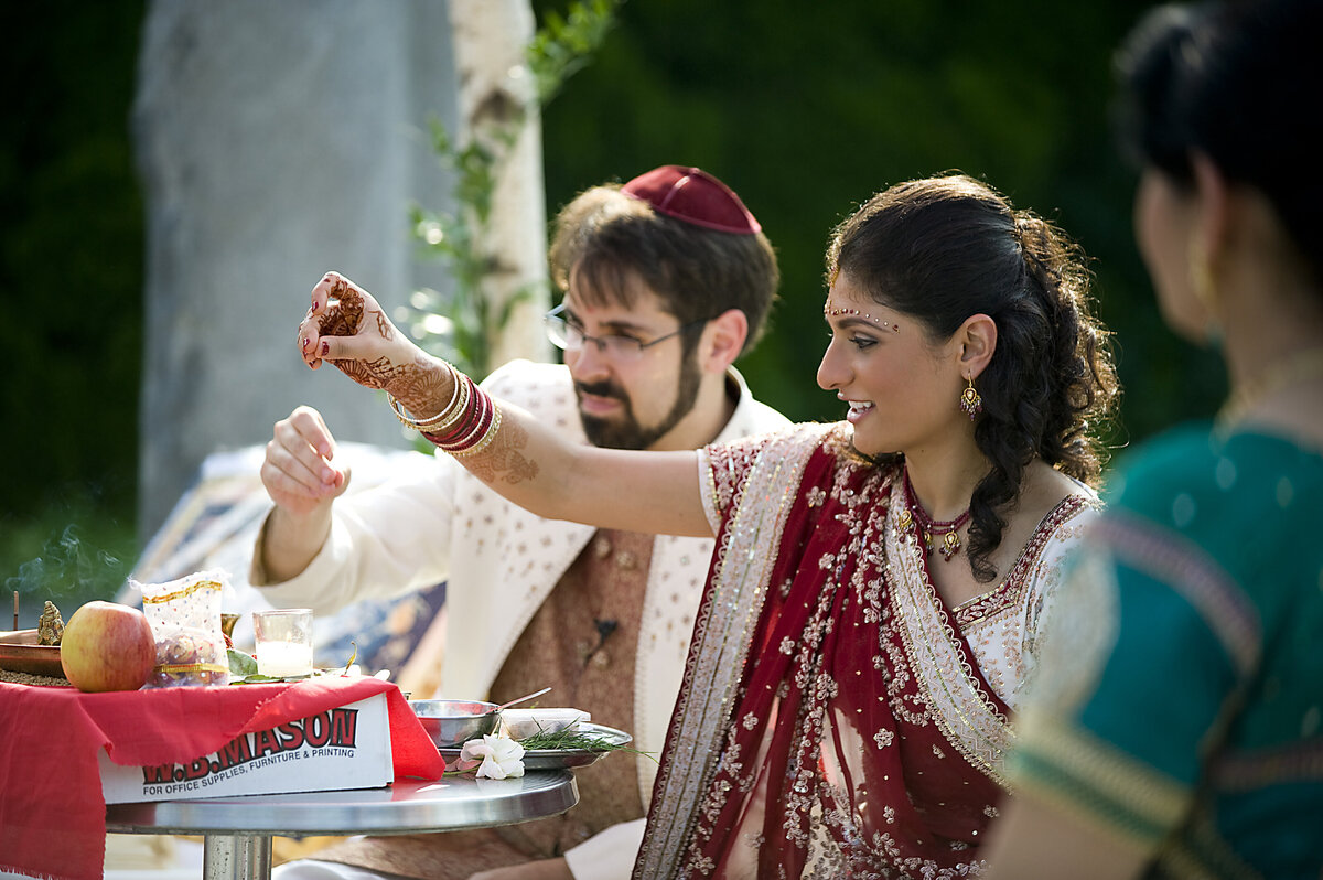A couple sitting down and sprinkling something on a table 