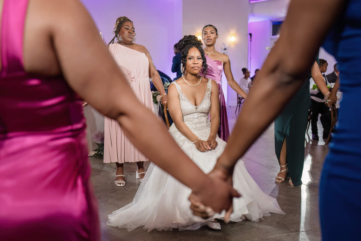 Bridesmaids assisting the bride with her dress before the ceremony at a stylish wedding.