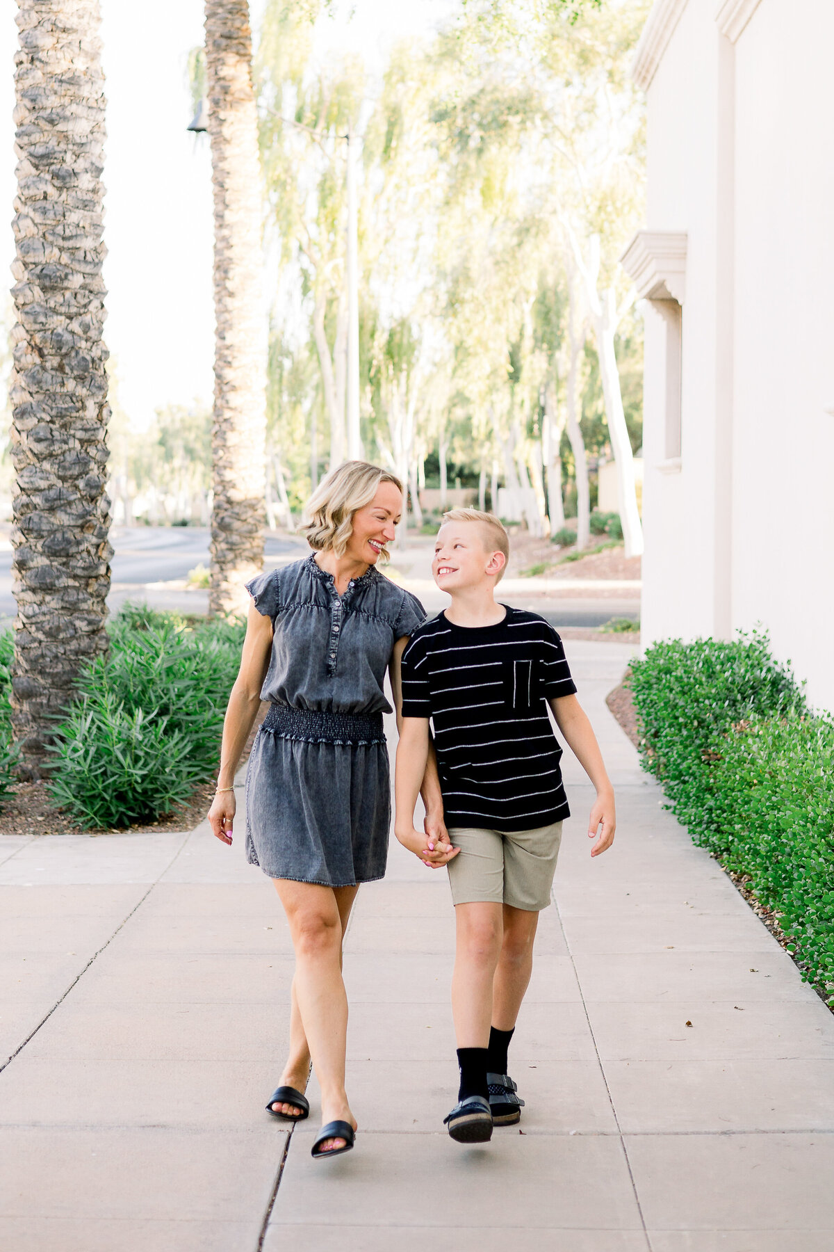 Mother and son smile and hold hands during family photography session in Buckeye, Arizona.