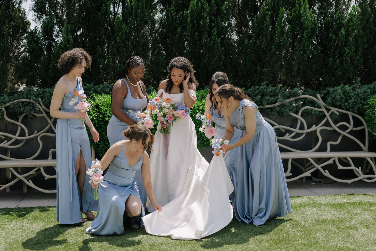 Bride and Groom walk hand in hand surrounded by their bridal party.