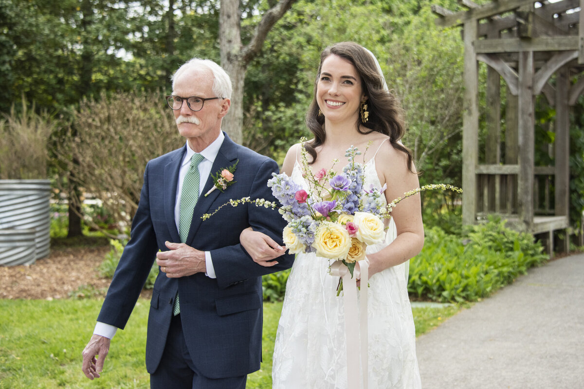 Bride and father walking down aisle at wedding