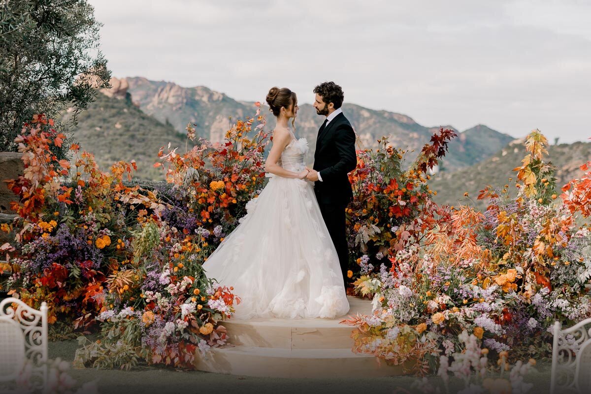 Romantic editorial style wedding at Cielo Farms in Malibu.  Large floral display at ceremony space overlooking the mountains.