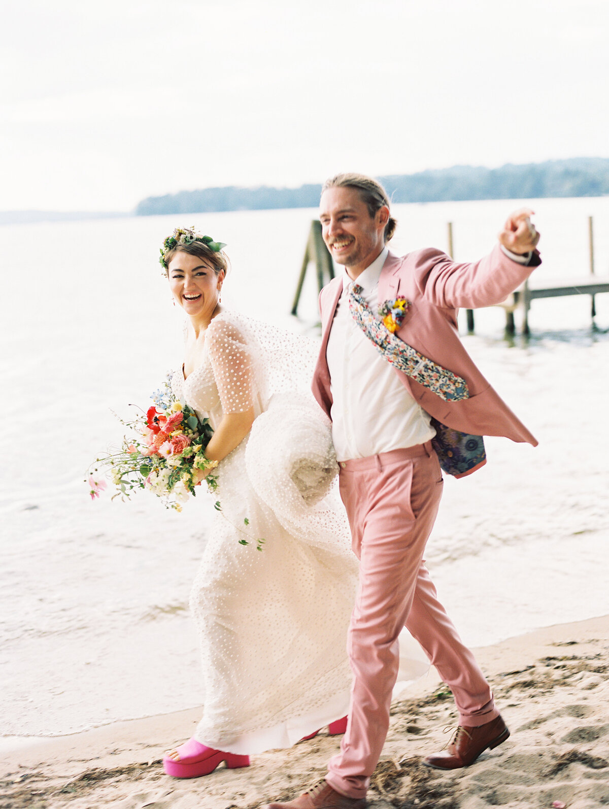 Couple walking along shoreline at Lake Winnipesaukee wedding