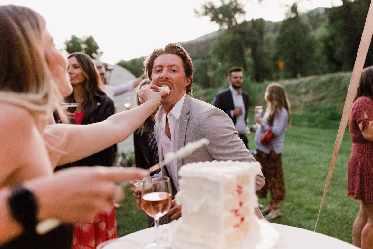 Man being fed wedding cake at Dallenbach Ranch Wedding reception Colorado
