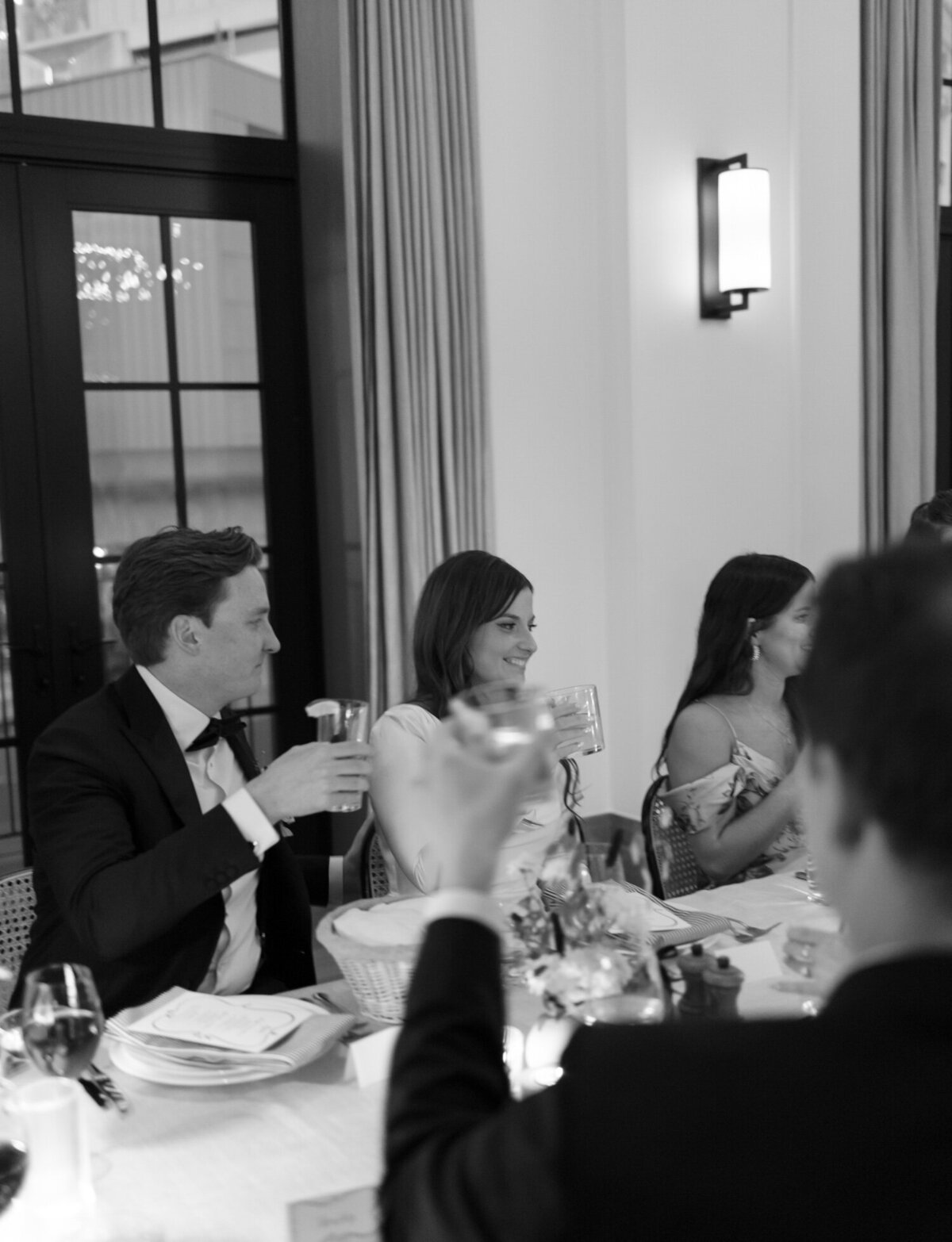 groom gazes at emotional bride during toasts at Shinola Hotel wedding reception