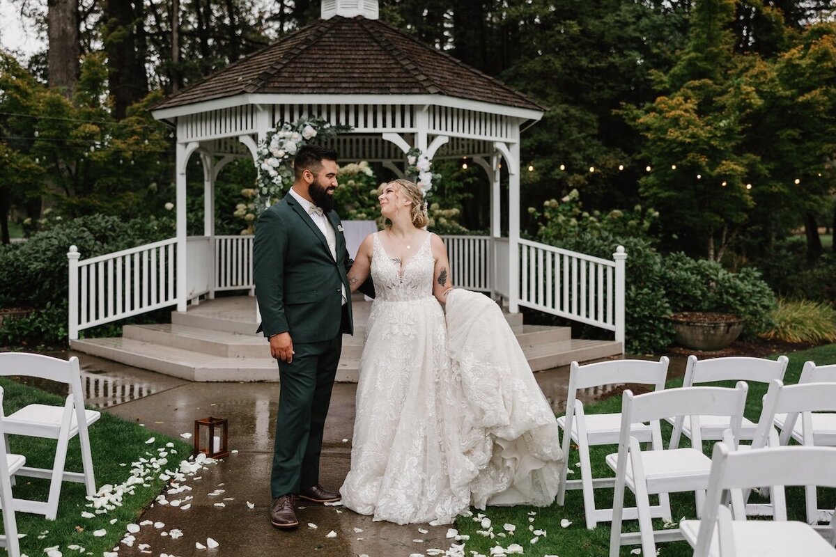 newly married bride and groom celebrate in front of their ceremony gazebo taken by a Vancouver WA wedding photographer