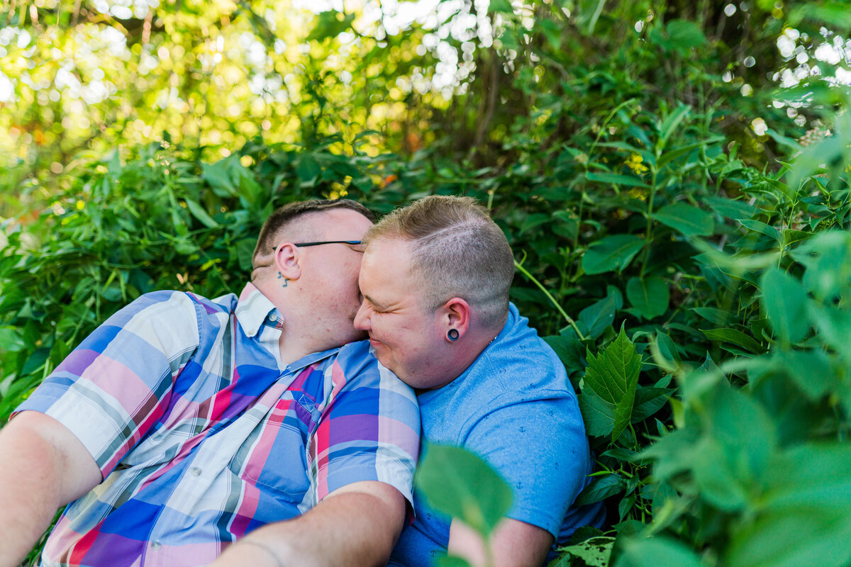 Couple sitting in a forest for their Rochester engagement session