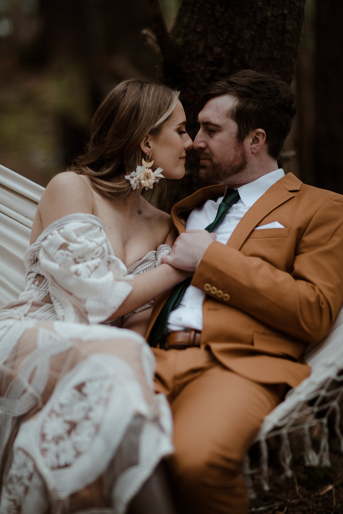 bride and groom sitting in hammock