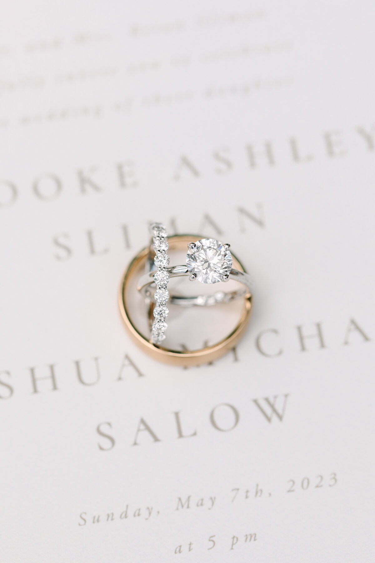 close up image of wedding rings on a wedding invitation.