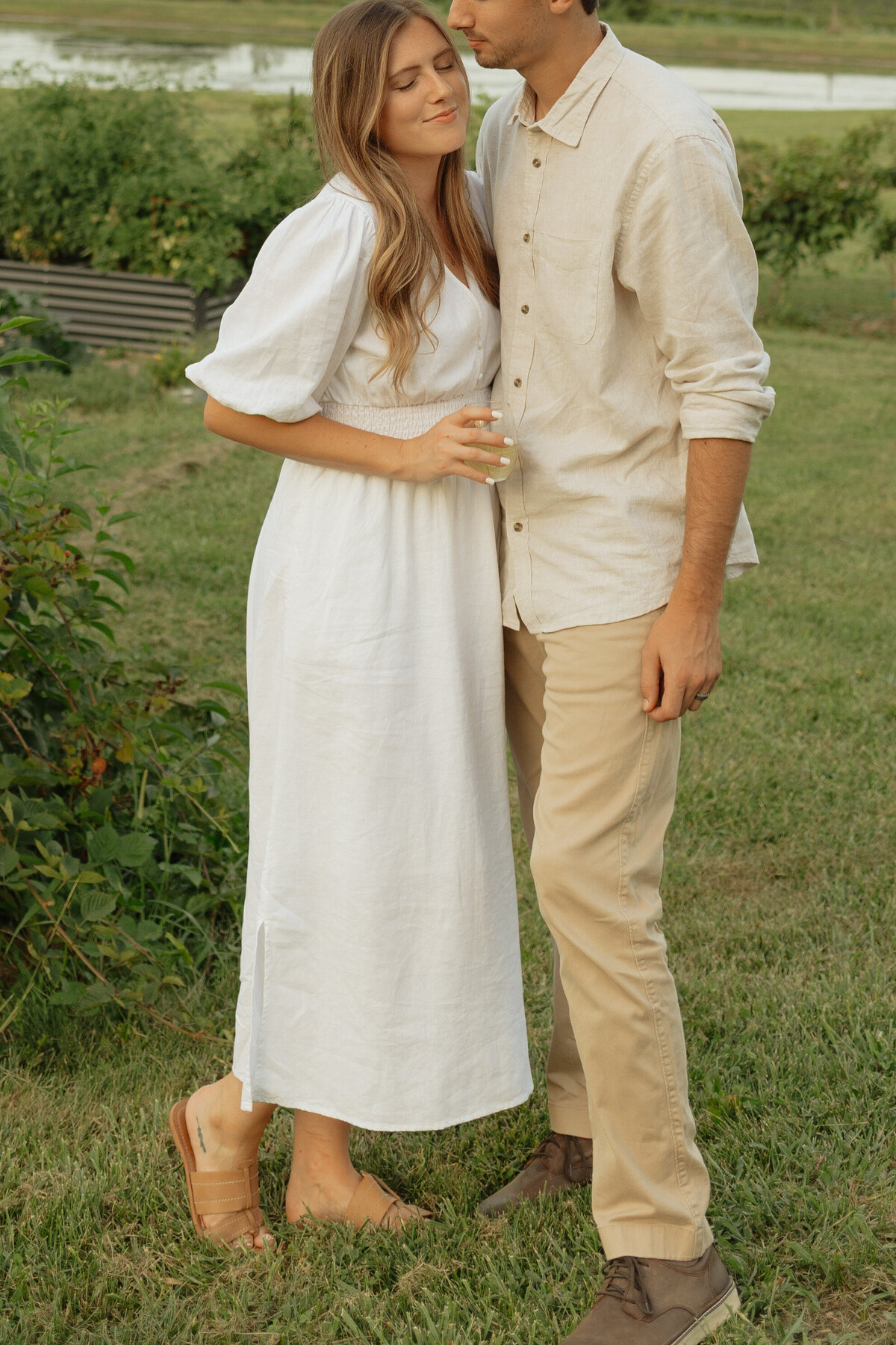 Couple enjoying a cozy picnic with wine and charcuterie at a tropical vineyard

