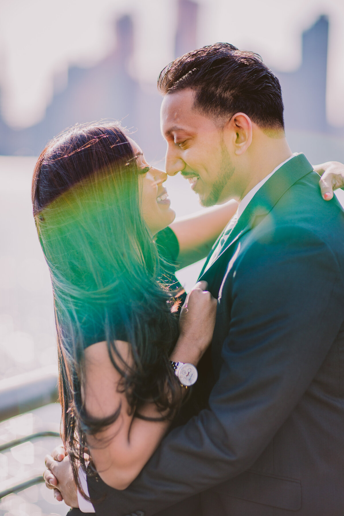 A couple sharing a moment at the promenade of gantry plaza state park in long island city ny with a greenish flair covering them