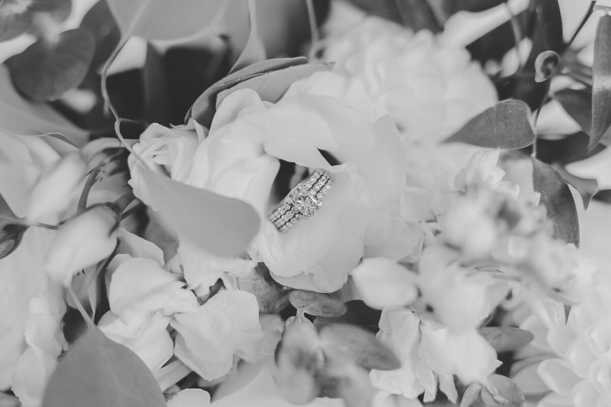 Black and White photo of a diamond wedding ring in a bridal bouquet