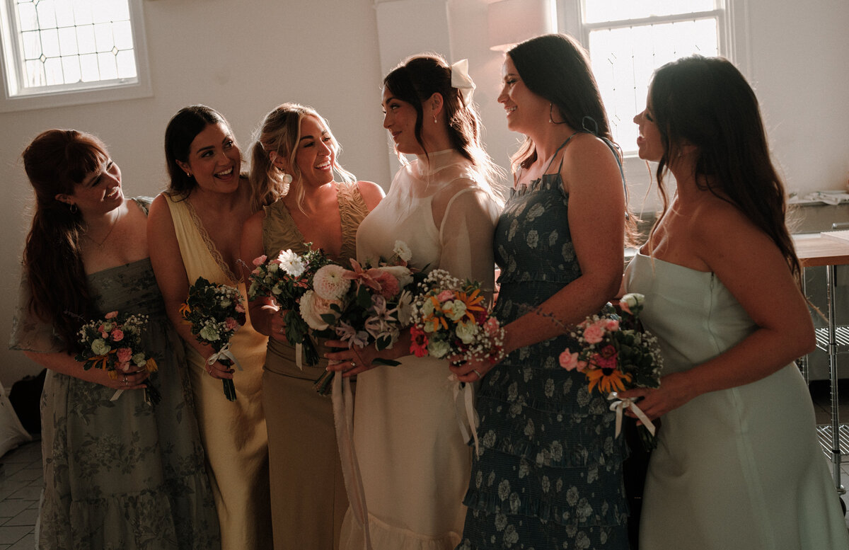 bride and her bridesmaids laughing with eachother naturally