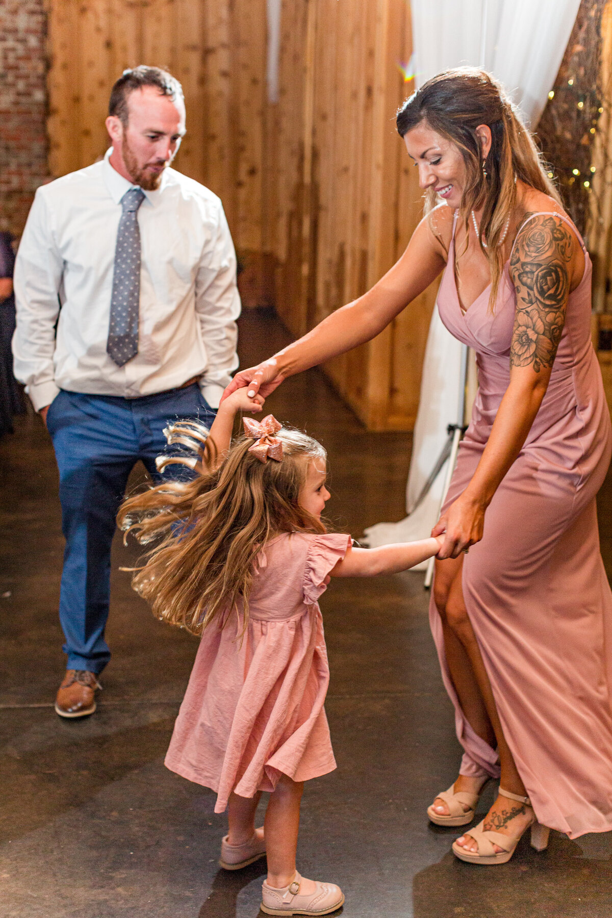 Wedding photo in West Jefferson, NC of a bridesmaid and her daughter dancing at a wedding reception.