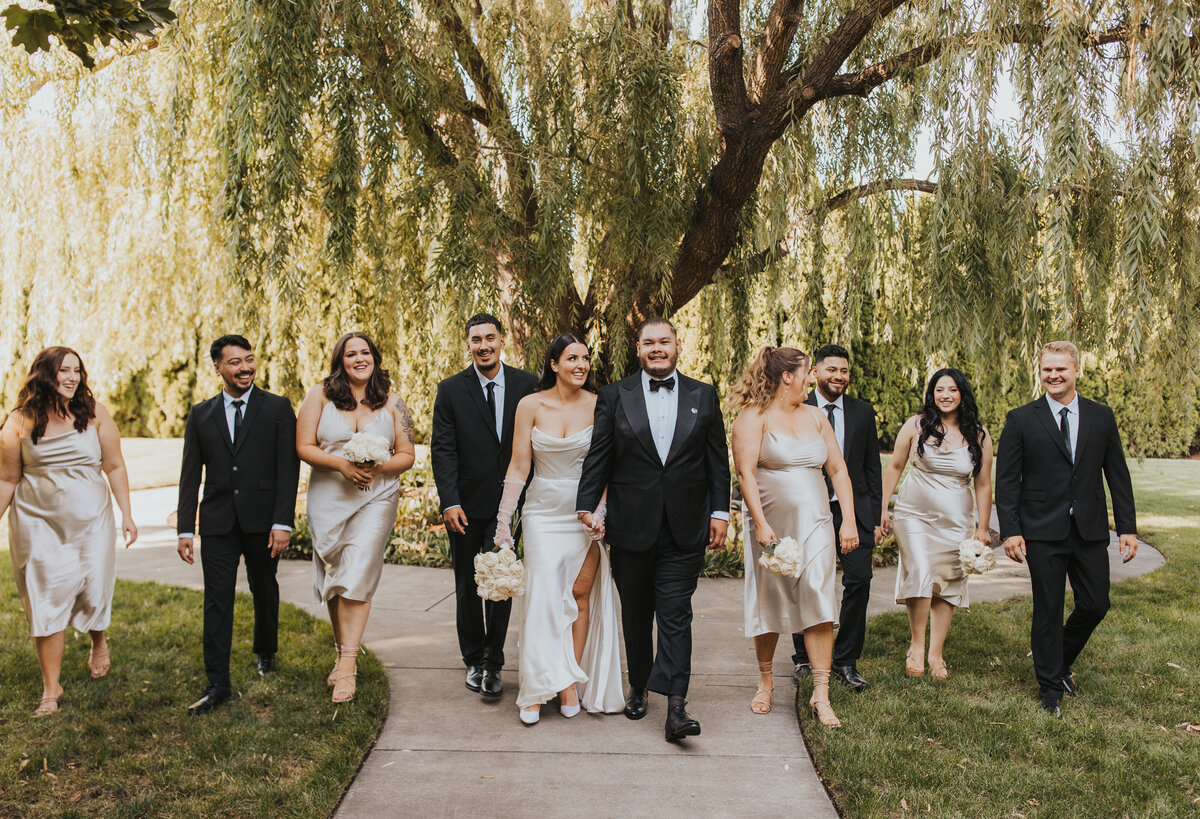 bride and groom walking with their wedding party