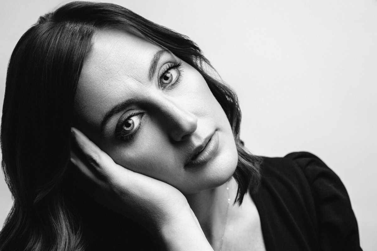 Black and White image of woman with black jumpsuit, necklace, and a serious face. Holly Springs, NC March 2025
