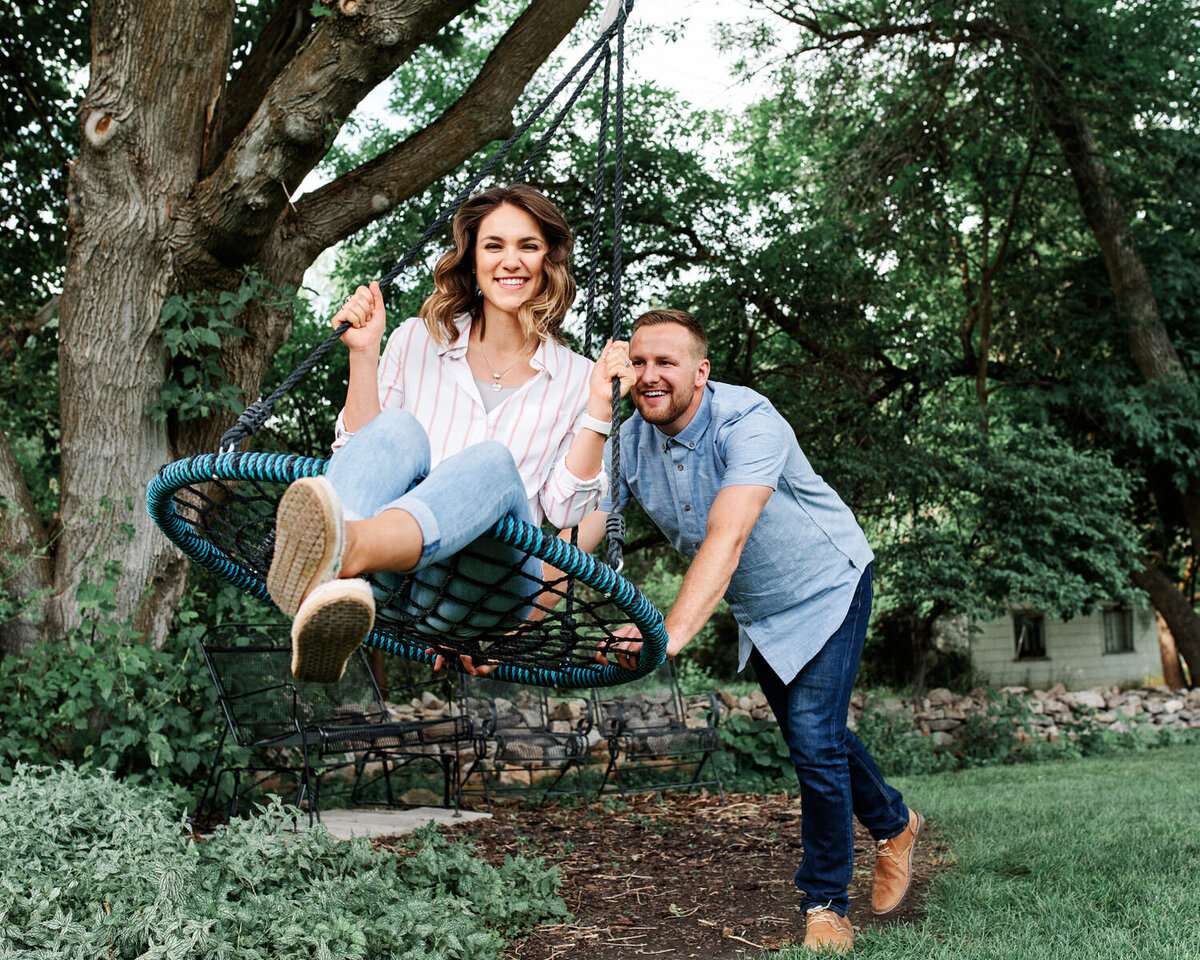 Couple smile in a tire swing