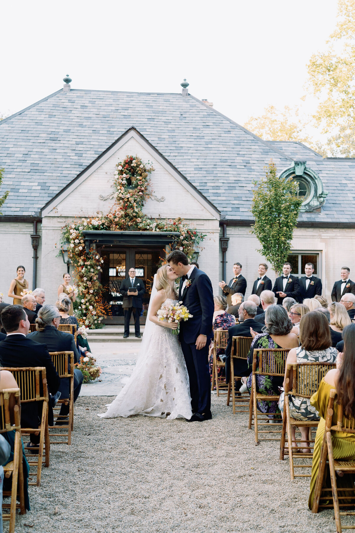 Organic growing floral installation for fall wedding ceremony backdrop. Private residence wedding build out for outdoor wedding ceremony and reception. Whimsical and organic floral design for autumnal wedding in colors of copper, yellow, blush, cream, and pops of orange. Clear tented wedding outside Nashville, TN. Design by Rosemary & Finch Floral Design in Nashville, TN.