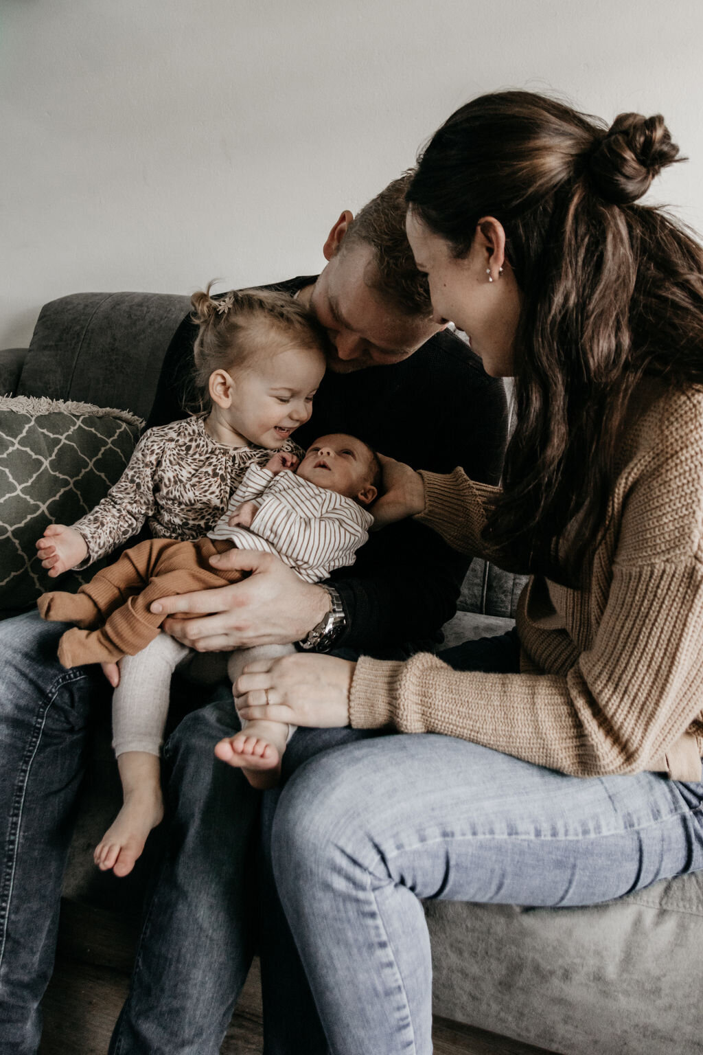 Gezin met newborn baby tijdens ontspannen newbornshoot