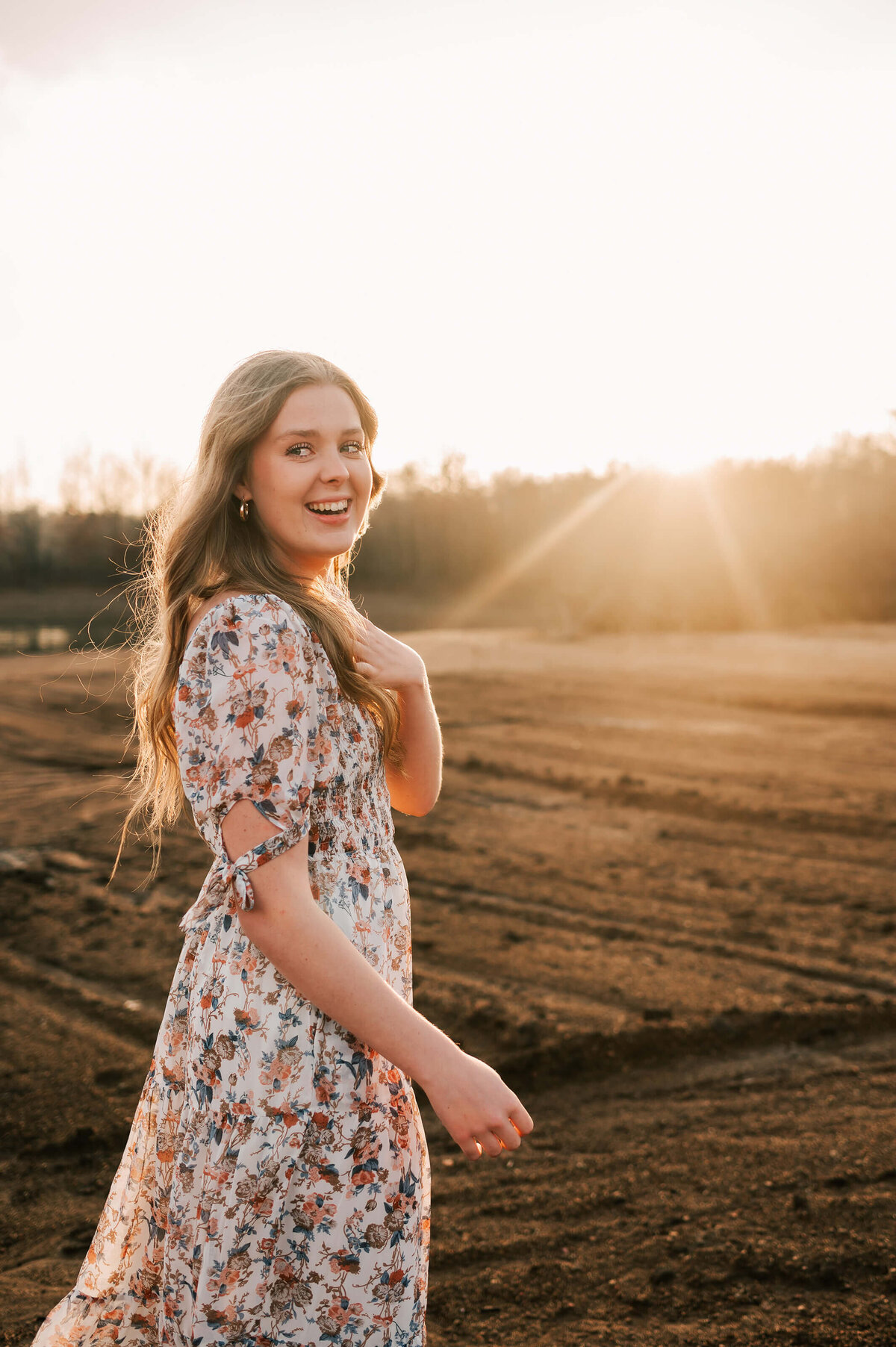 Branson senior photographer captures girl laughing at sunset during senior photography session in Branson