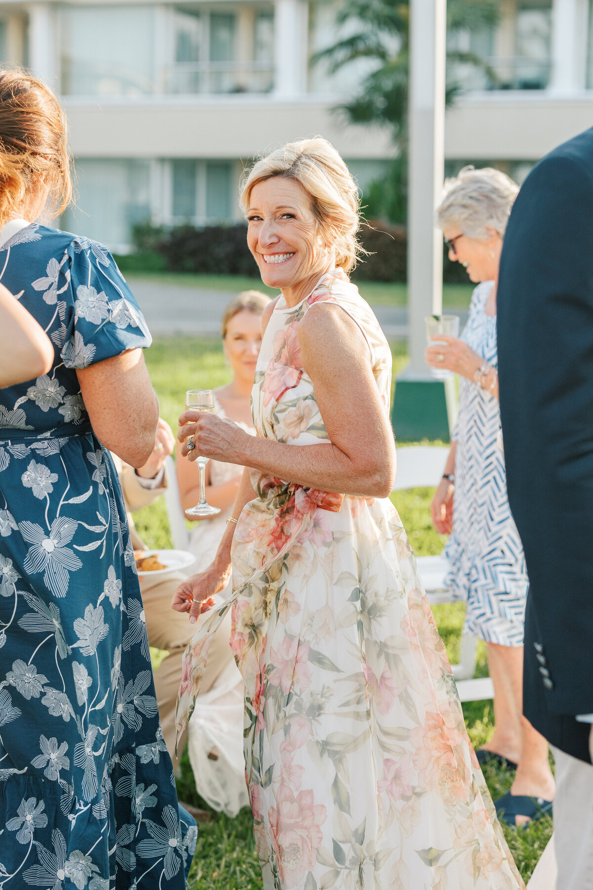 Mother of the bride smiles in a floral gown at a Cancun wedding reception, documented by a Philadelphia wedding photographer.