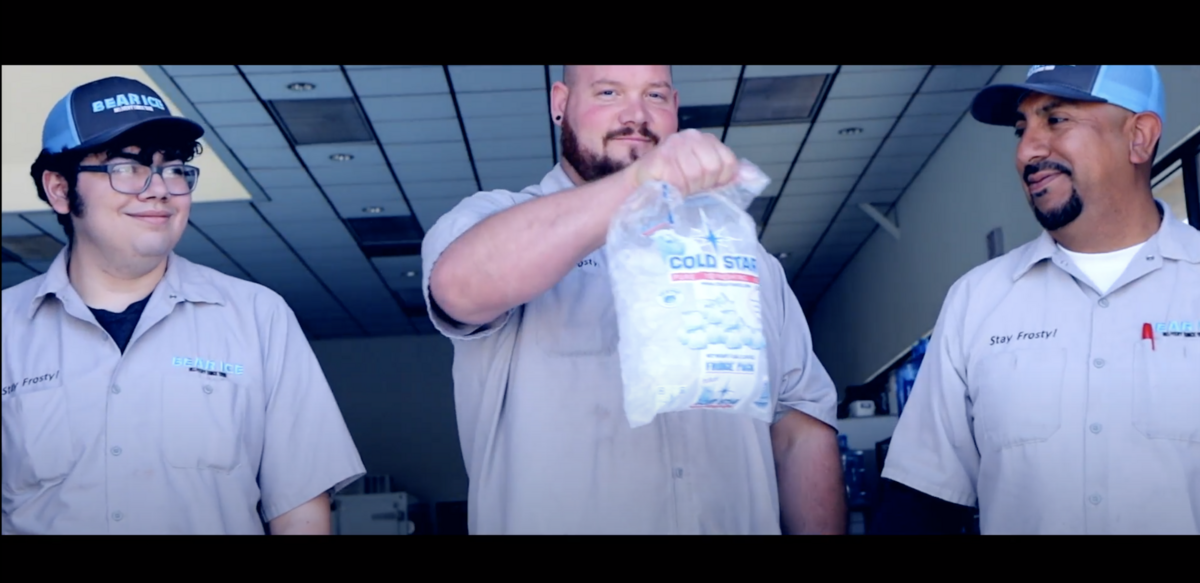 Three Bear Ice Employees standing in line next to each other passing a five pound bag of ice to each other