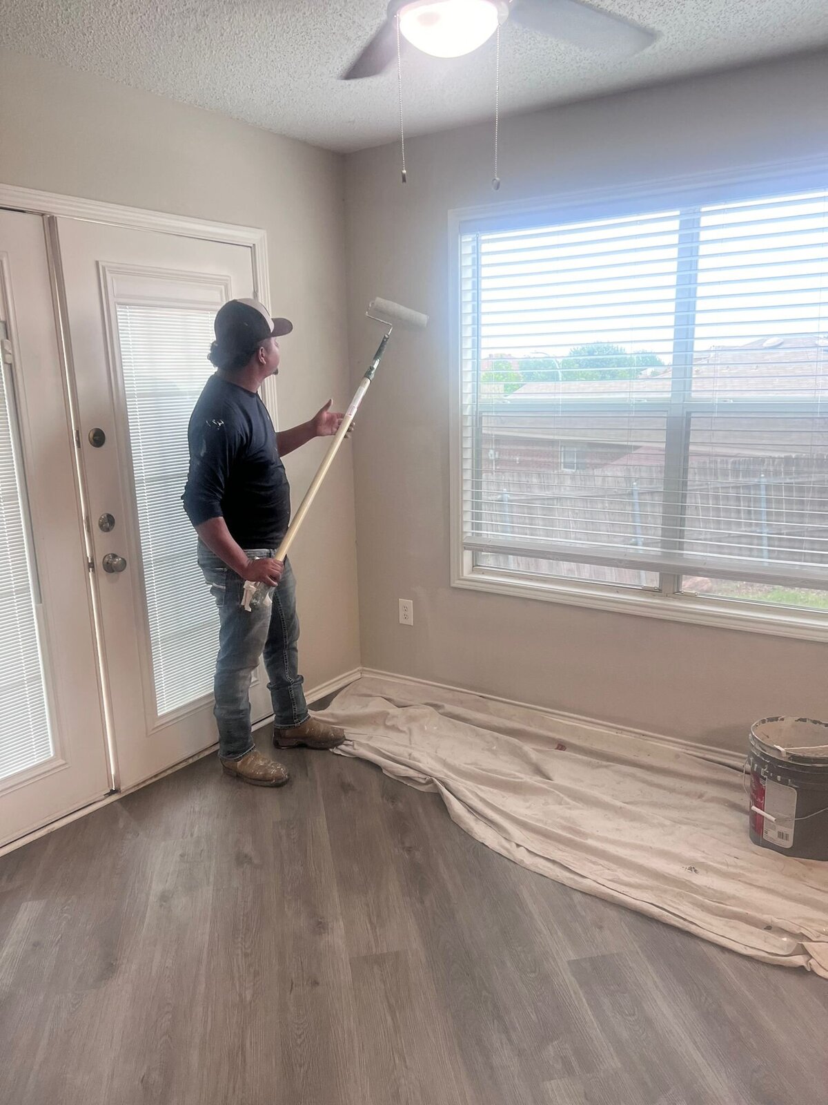 A professional painter expertly painting the interior of a house in Dallas, TX. This image showcases the precision and care taken during interior painting projects, highlighting the quality work provided by Dallas home renovation experts.