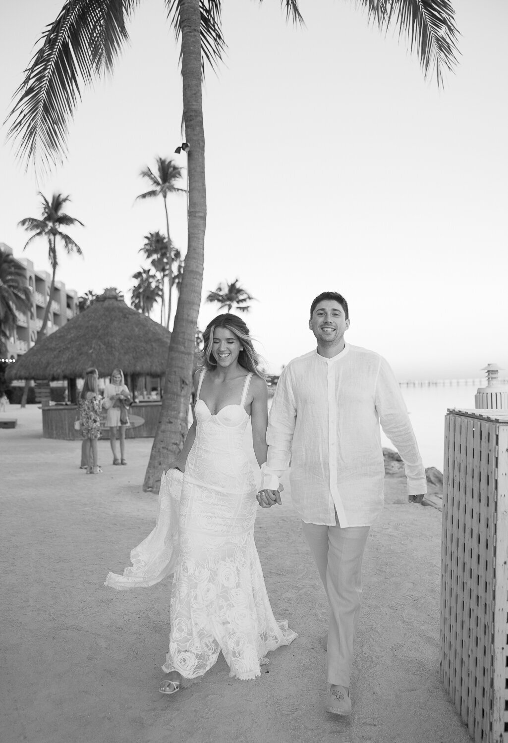 Black and white wedding portrait of Laura and Abraham walking hand-in-hand at Cheeca Lodge Resort.