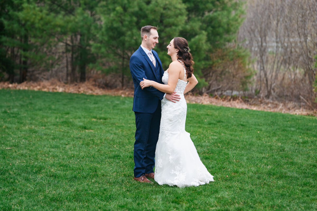 First look between bride and groom on a tree-lined path