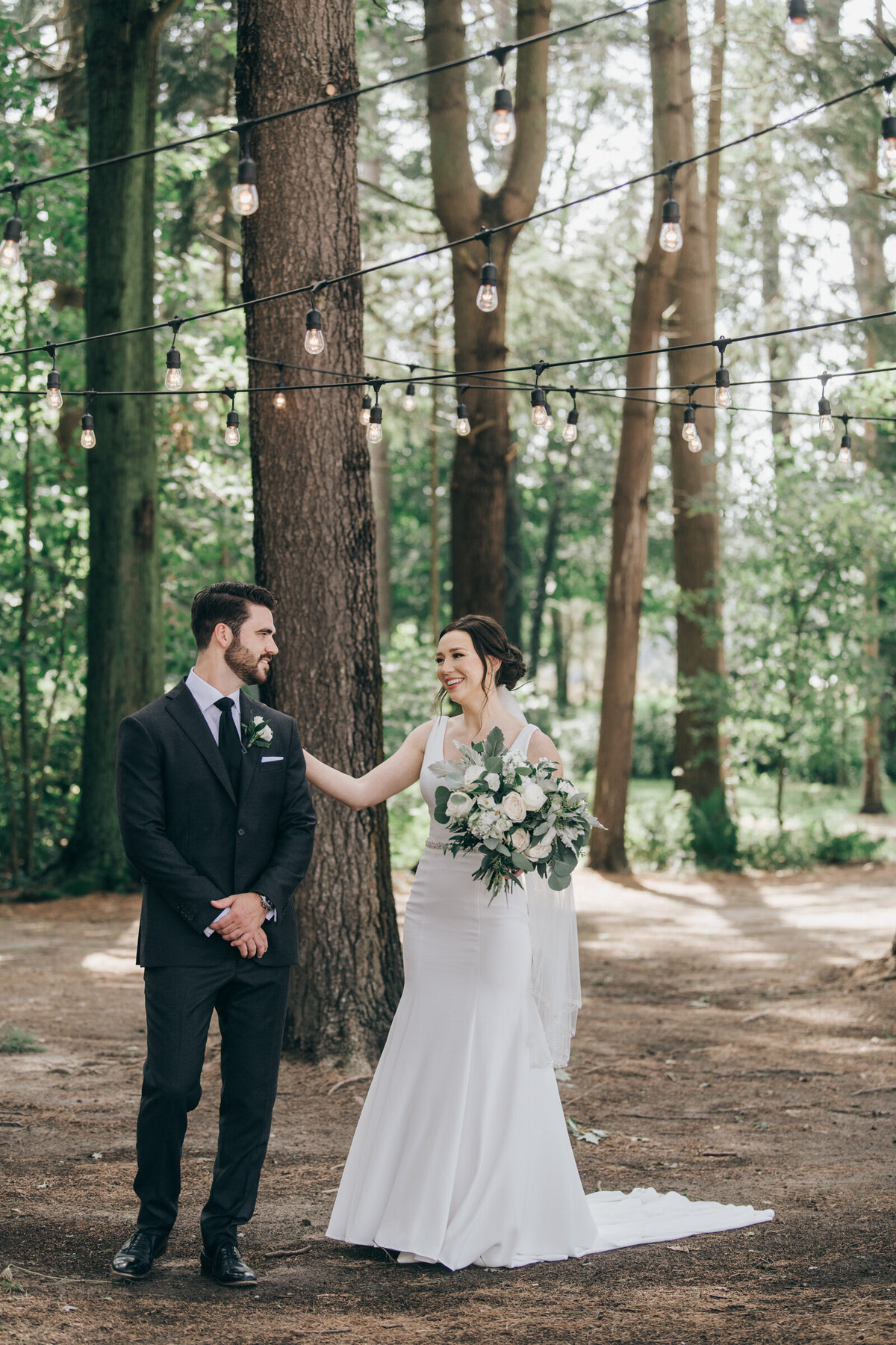 A bride walking up to her groom for a romantic first look in an enchanted forest