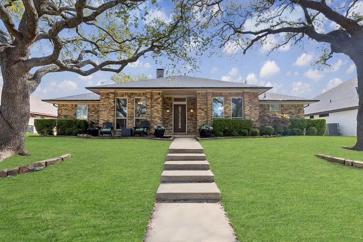Charming ranch-style home on Shadow Way in Dallas, TX with mature trees and wide lawn in quiet residential neighborhood.