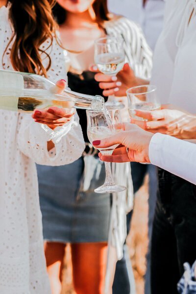 woman pouring drinks to celebrate travel concierge for luxury GG Mack Travels