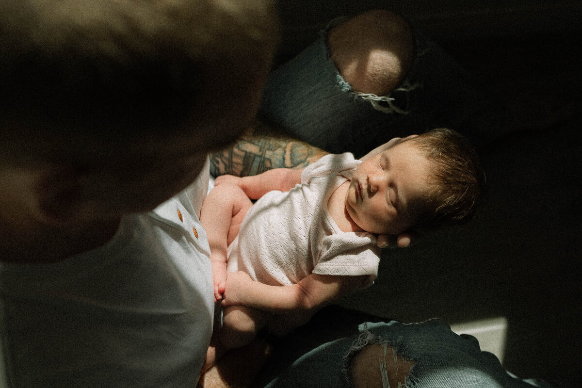 Dad holding baby in dramatic light at home in Temecula.