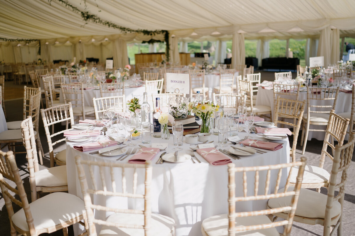 Bud vases of flowers on the round tables in the marquee